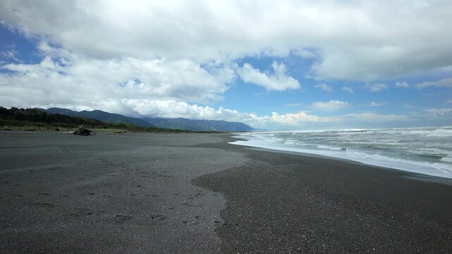Wide Dark Sand Beach With Mountain Coast