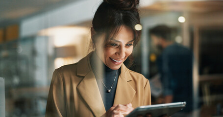 Woman, tablet and smile at window at startup for review, night and feedback for article at company. Person, happy and editor with solution by glass on tech, proposal or application at media agency © peopleimages.com