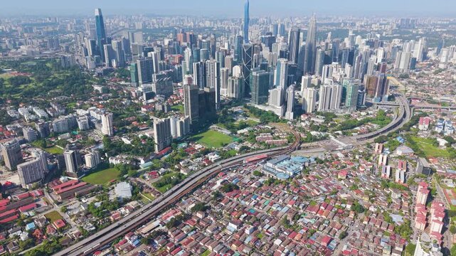 Drone shot of Kuala Lumpur City Centre pushing into Kampung Keramant. Iconic skyscrapers like Exchange 106, KL Tower, Petronas Twin Towers and Merdeka 118 Tower. Malaysia