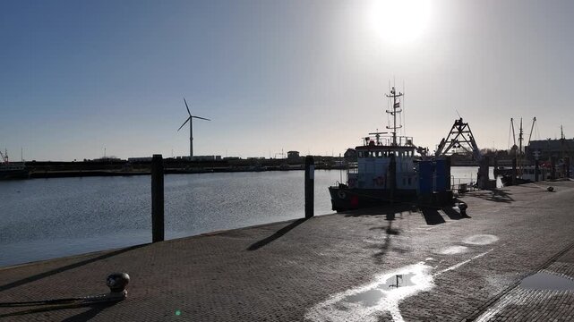 Harbor silhouette at dam end with boat and turbine