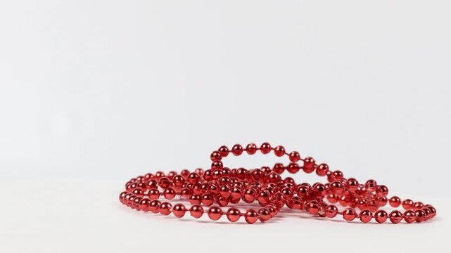 A strand of red plastic beaded necklace. Close-up, front view.