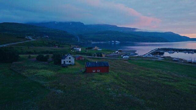 Kokelv, Hammerfest, Finnmark, Norway - A Serene Village Sits by the Coast, Surrounded by Colorful Houses and Mountains - Orbit Drone Shot