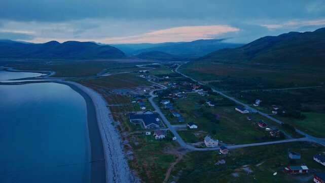 Kokelv, Hammerfest, Finnmark, Norway - The Village Rests Along the Coast, With Winding Roads and Colorful Houses Nestled Between the Water and Hills - Orbit Drone Shot