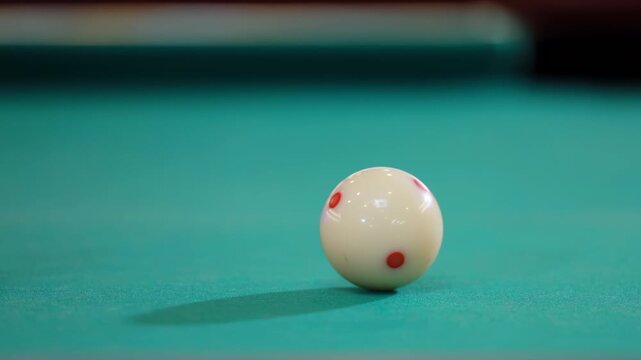 Billiard pool table shows black eight ball arranged for game play, is hitting by the white cue ball with the cue close up in a well-lit space with felt and wood surfaces. Classic cue sport equipment