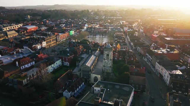 Aerial view of St Thomas Church and surrounding Salisbury city centre in warm sunrise light showing historic buildings and urban landscape in Wiltshire England