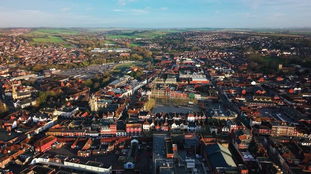 Aerial view of Salisbury city centre and market square showing historic buildings shops and urban layout in warm evening light in Wiltshire England