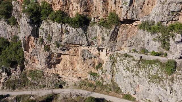 Aerial panorama of Holy Kipinas Monastery perched dramatically on a cliff in Pindus mountains