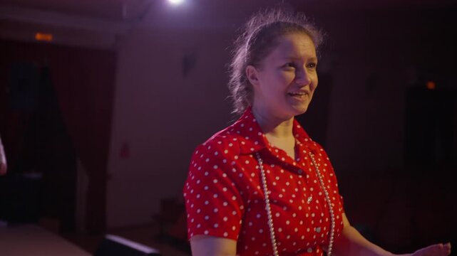 Community theater rehearsal on stage with passionate director guiding performers in vintage costumes under dramatic lighting during emotional scene practice