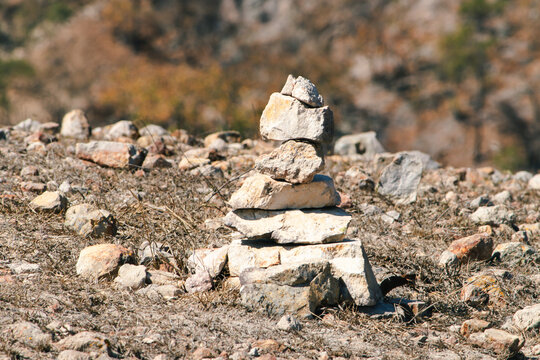 Close-up of a rustic stone in a dry, natural landscape with soft sunlight and earthy tones.