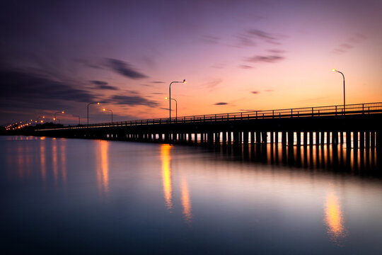 Silhouette of the iconic Windang Bridge, connecting the suburbs of Lake Illawarra south and Windang, captured with a long exposure as the sun retreats leaving a golden glow in the west. 