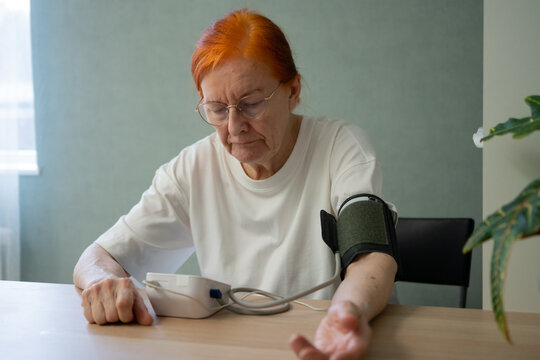 A close-up reveals a senior lady with a puzzled look as she examines her blood pressure tonometer. confusion or contemplation during the essential daily health check routine