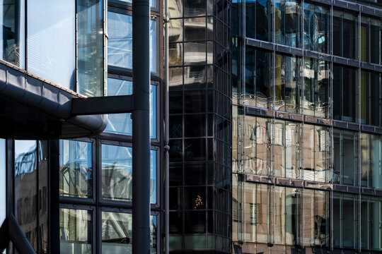 Reflection on glass lines emphasizes the corner of a modern geometric exterior in facade architecture building with sleek urban mood