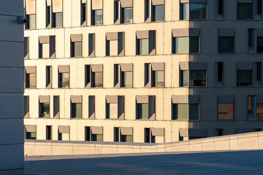 Shadow across windows creates modern grid pattern on geometric exterior of a facade architecture building with crisp detail and depth