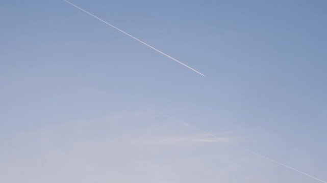 Airplane contrail against a clear blue sky.