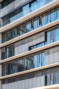 Contemporary architecture exterior showing glass facade windows with linear lines and modern pattern creating a clean design on a sleek building