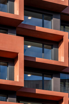 Contemporary architecture exterior featuring balconies and windows on modern apartments facade with geometric pattern and bold modular design