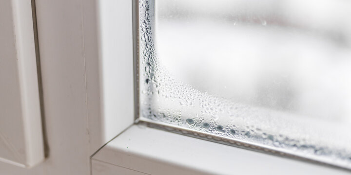 Window corner with condensation droplets on interior sill