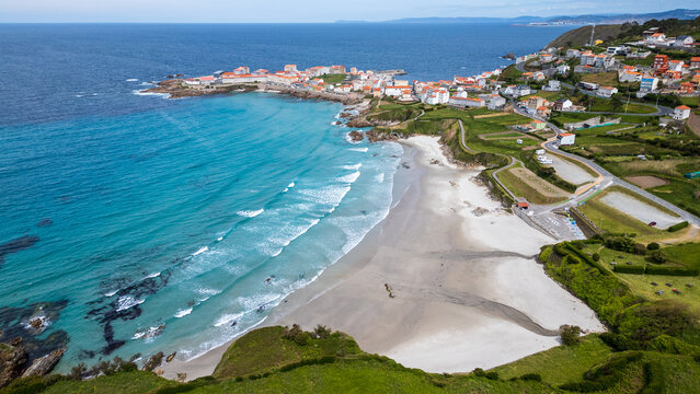 Aerial view of the picturesque coastal village of Cai&oacute;n and its beach, Galicia, Spain.