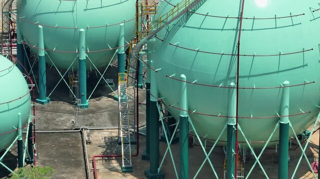 High-angle aerial shot of gas storage spheres and surrounding facilities, symbolizing global energy infrastructure, industrial logistics, the transition toward cleaner and more sustainable practices.