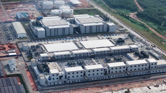 High angle drone aerial of expansive data center complex with solar arrays and cooling infrastructure