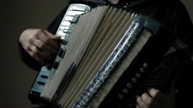 Male musician plays accordion with focused expression, fingers pressing keys and bellows expanding in a dimly lit indoor setting, showcasing musical artistry and craftsmanship, balkan