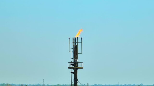 Aerial drone view of an oil refinery flare stack releasing burning gas, highlighting industrial energy production, petroleum processing, and environmental impact in the modern energy sector. 4k.

