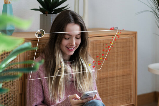 Smiling young womausing smartphone for social media at home indoors