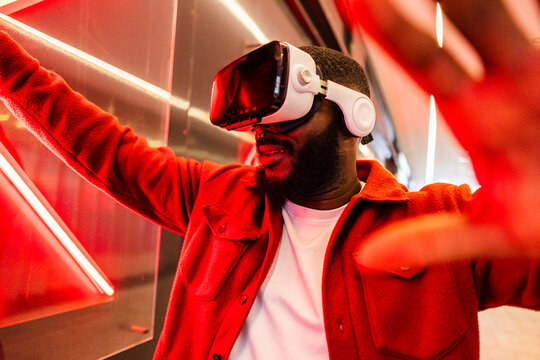 Man using VR headset in immersive urban neon setting
