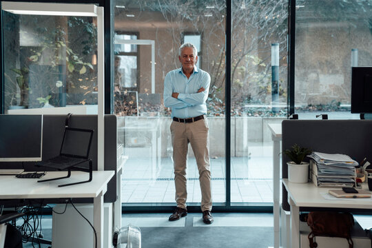 Boss standing confidently in modern office at agency