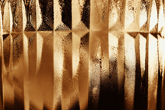 Abstract close-up of warm textured glass with geometric lines