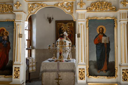 Orthodox Church Interior with Golden Iconostasis and Priest Performing Baptism Ceremony in Cathedral