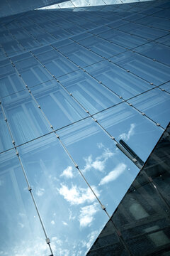 Modern architecture of a glass roof skylight structure where blue lines frame sky reflection creating a clean contemporary design detail