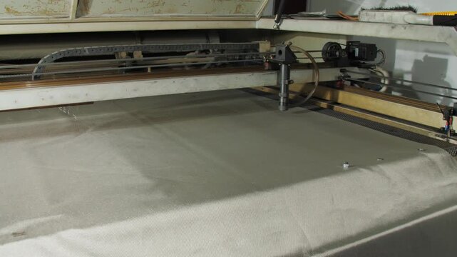 Radio-blocking fabric expertly handled in manufacturing workshop. Machine precisely shapes shielding material for electromagnetic protection