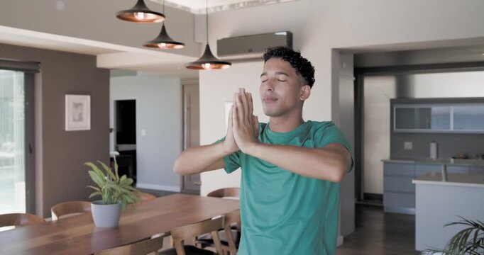 African man raising lowering arms to prayer meditating opening eyes gazing at doors smiling in home