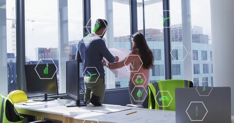 Examining colleagues in office, wearing pink blazer, pointing at plans with helmet and AR icons © vectorfusionart