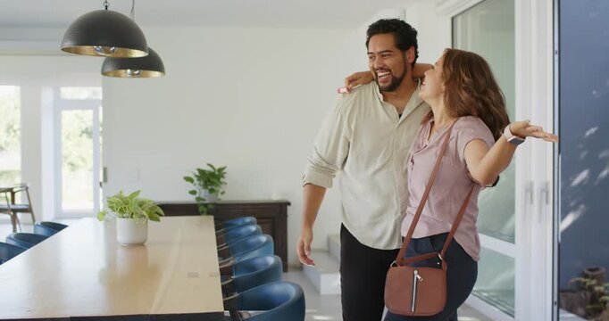 Romantic couple arriving in dining area, embracing while admiring table and red key fob, copy space
