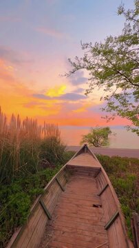 Dramatic vertical footage of the "burning sky" phenomenon at dusk. Deep orange hues saturate the clouds and water reflections in Dali, creating a stunning spectacle.