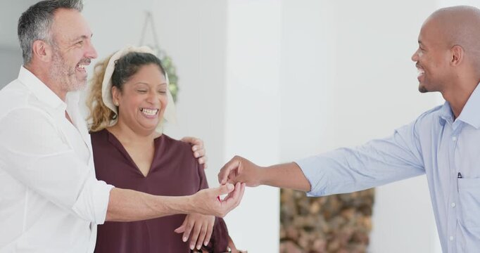 Diverse couple receiving red key fob as African American agent extending for new home in entryway