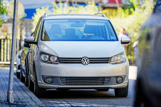 Brno, Czech Republic - April 10, 2026: Parking cars in the city on the street. View of the front of an older family car MPV Volkswagen Touran standing along the sidewalk in a parking space.