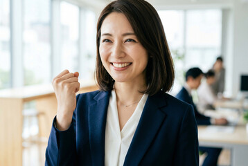 Obraz premium オフィスでガッツポーズをして笑顔を見せる日本人女性のビジネスパーソン Generative AI
