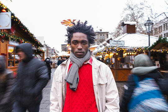 Man wearing scarf at urban Christmas market in winter