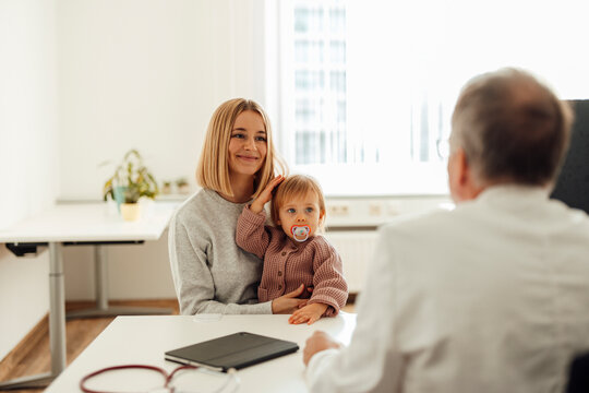Mother with child at pediatrician consultation in hospital office