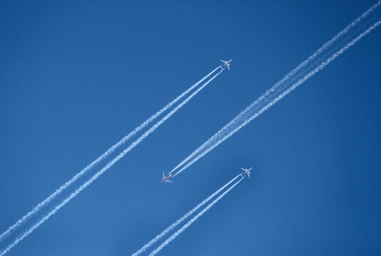Planes leaving contrails against a clear blue sky