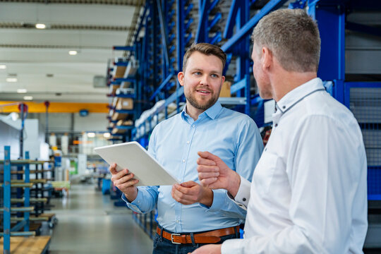 Business discussion with tablet in modern production hall