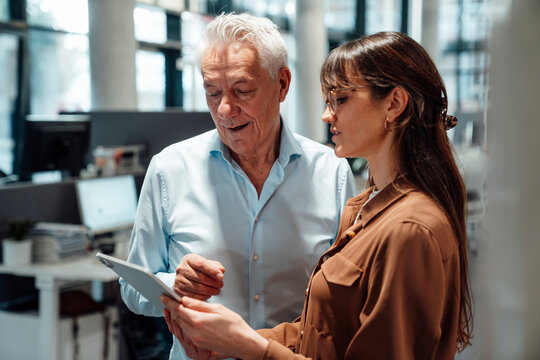 Team members collaborating in a modern office with tablet