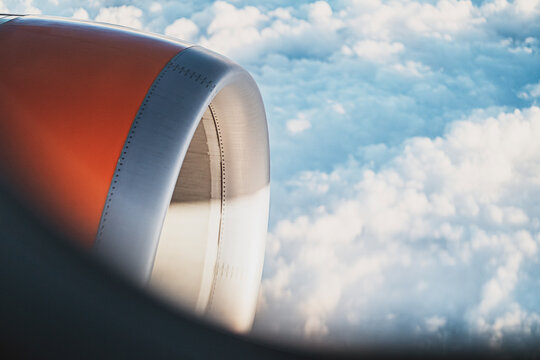 Aerial view of airplane engine with clouds in the sky