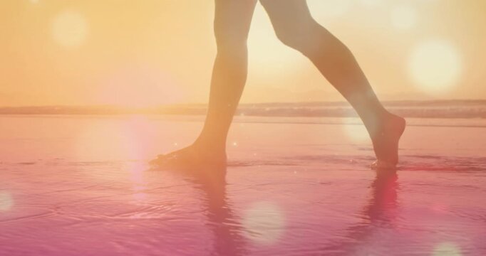 Camera beginning low, lower legs walking, flat contacts on wet sand, toe push-offs crossing frame