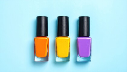 Obraz premium Three colorful nail polish bottles arranged on a pastel blue background.