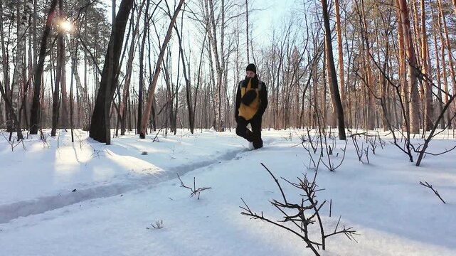 Explorer In Snowy Woods. Wanderer Moving Across Snowladen Forest Path Under Bright Sunlight. Excursionist Journeying Through Frosted Woods Along Sundappled Snowy Trail Surrounded By Luminous Trees
