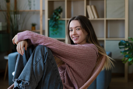 Relaxed woman sitting casually at home in natural light